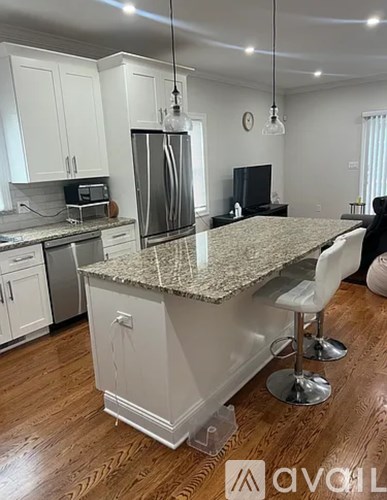 A kitchen with granite countertops and white cabinets.