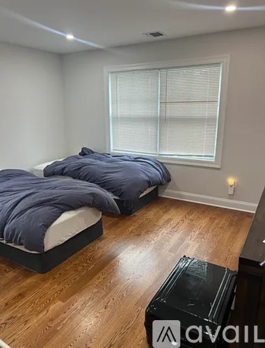 A bedroom with two beds and a wooden floor.