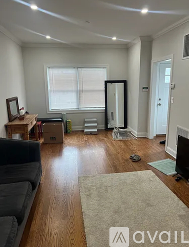 A living room with a couch, a rug, and a television.