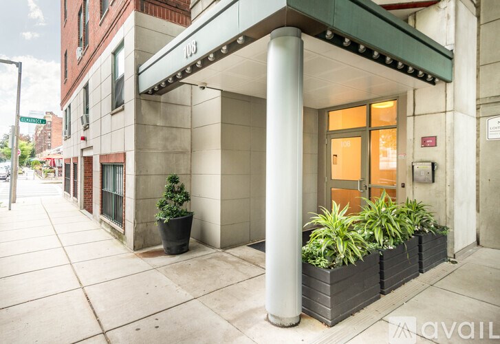 A building with a green awning and a white pillar in front of it.