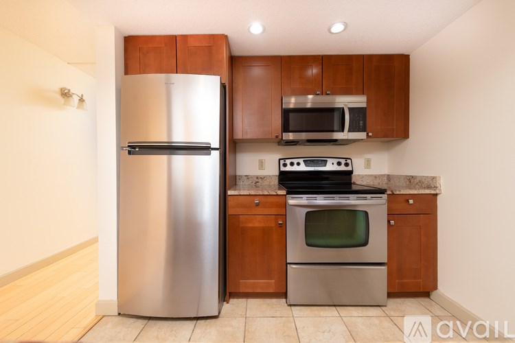 A kitchen with a stainless steel refrigerator, microwave, and oven.