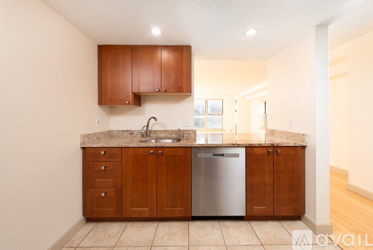 A kitchen with brown cabinets and a marble countertop.