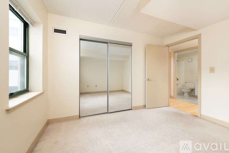 A room with a window, a sliding door, and a carpeted floor.
