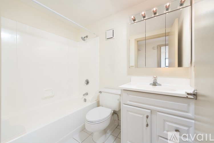 A white bathroom with a toilet, sink, and mirror.