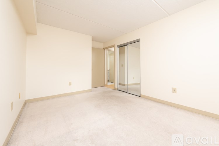 A spacious empty room with a door on the right side.