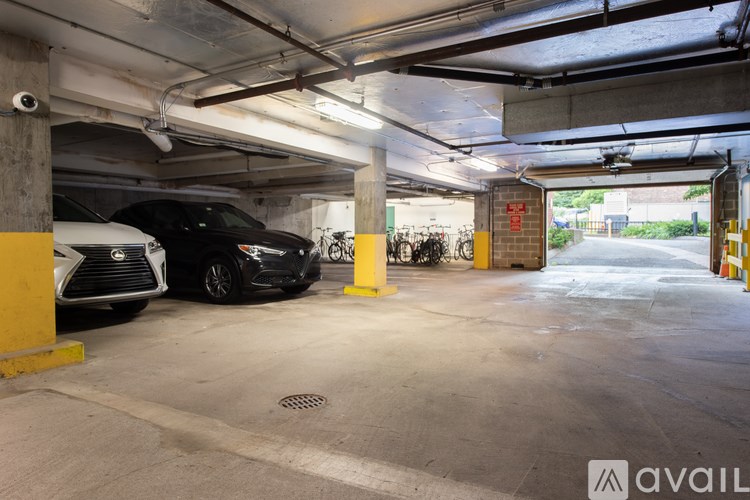 A parking garage with a Lexus and a black car parked in it.