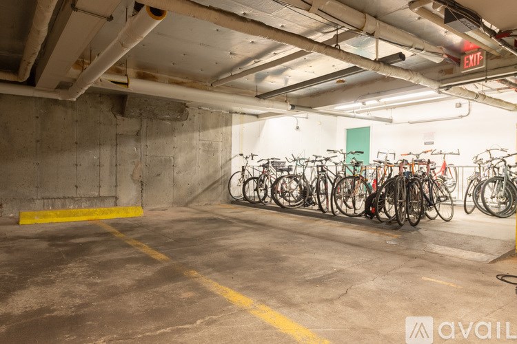 A parking garage with a yellow line and bicycles.