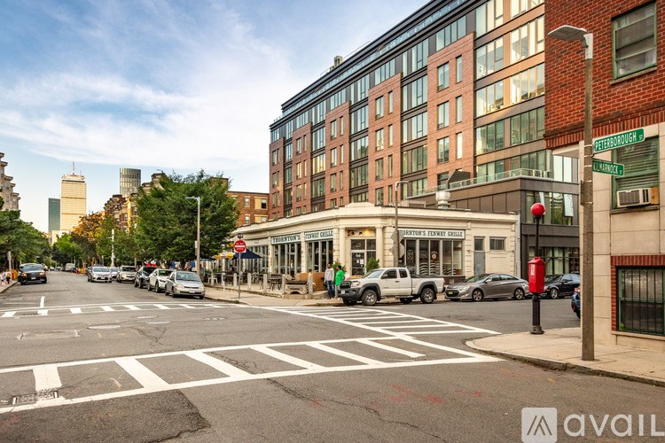 A street view with a crosswalk, cars, and buildings.