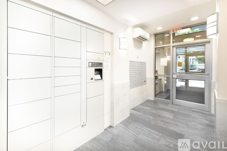 A hallway with a white wall and a door with a glass window.