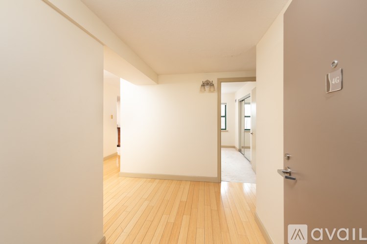 A spacious room with wooden floors and white walls.