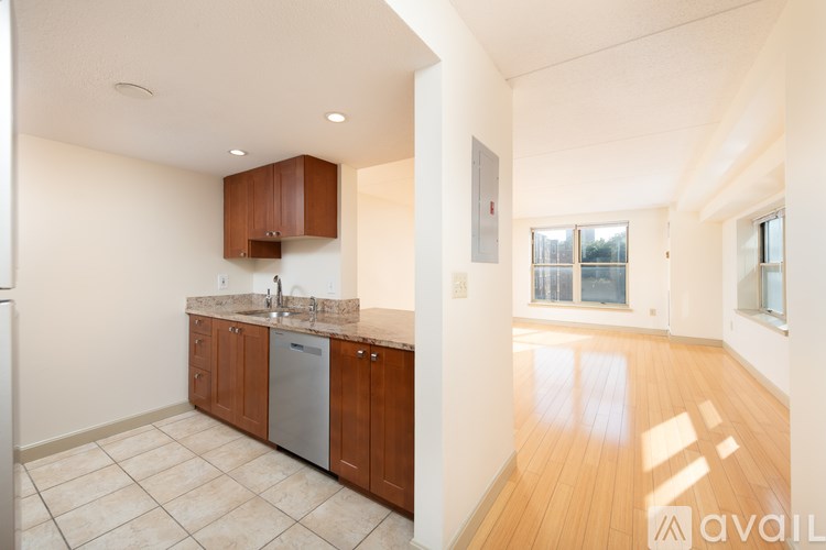 A kitchen with wooden cabinets and a marble countertop.