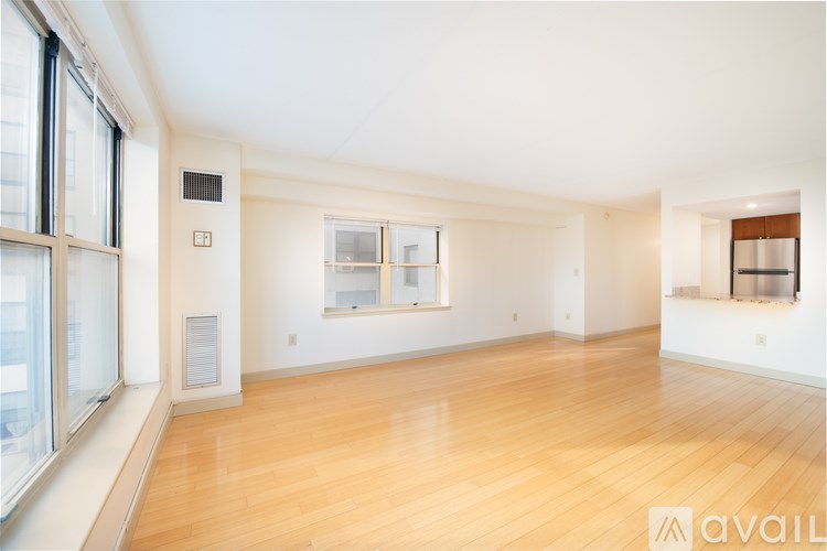 A spacious room with wooden floors and large windows.