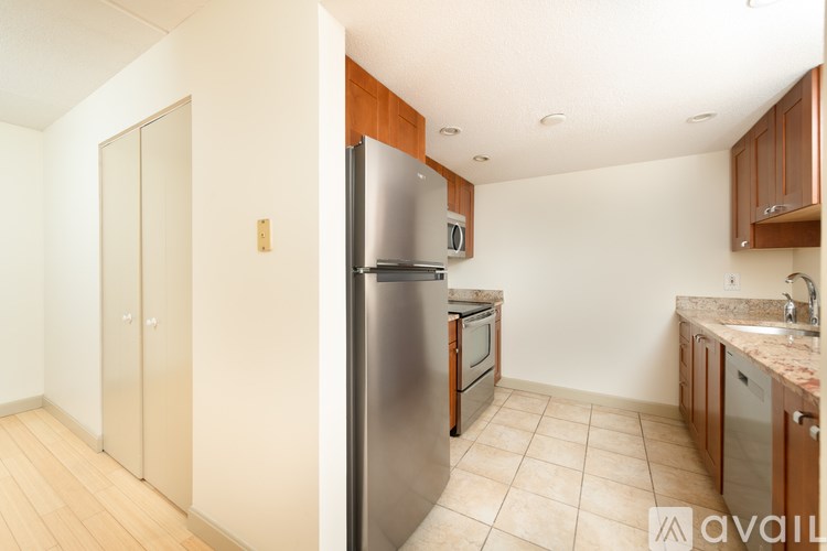 A kitchen with a refrigerator, microwave, oven, and sink.