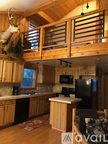 A kitchen with wooden cabinets and a black fridge.