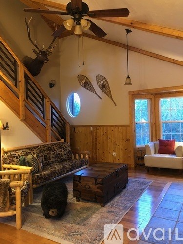 A living room with a couch, a coffee table, and a ceiling fan.