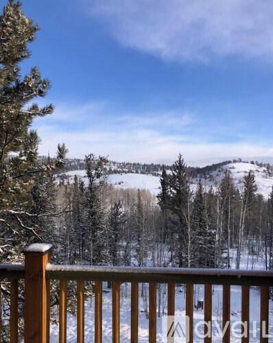 A snowy mountain landscape viewed from a deck.