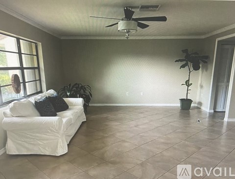 A living room with a white couch and a ceiling fan.