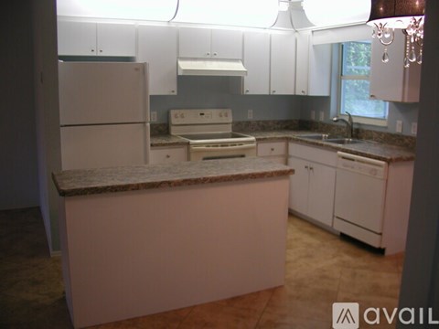 A kitchen with white cabinets and a marble countertop.