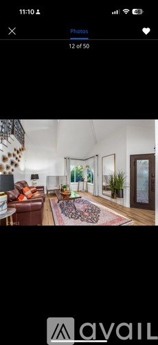 A living room with a brown leather couch and a rug.