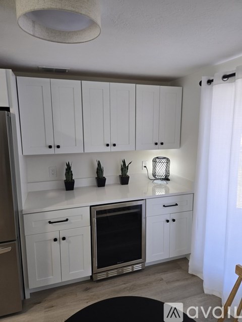 A kitchen with white cabinets and a black oven.
