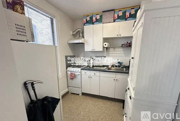 A kitchen with white cabinets and a black stove top.