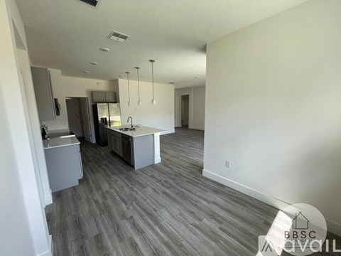 A kitchen with a sink and a refrigerator.