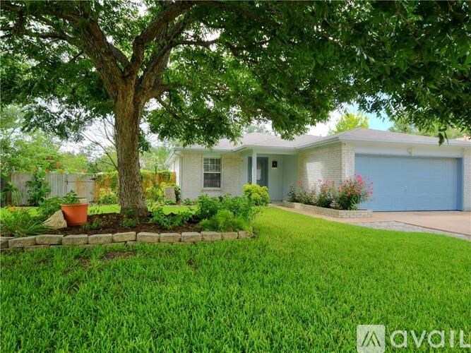 A tree in front of a house with a sign that says "available".