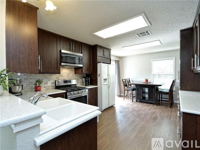A kitchen with dark wood cabinets and a white countertop.