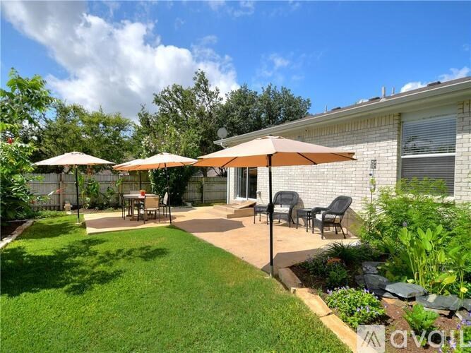 A patio with a table and chairs under umbrellas.