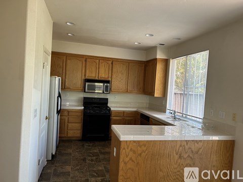 A kitchen with wooden cabinets and a black stove top oven.