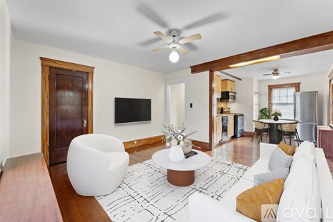 A living room with a white rug and a brown coffee table.