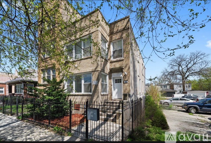 A house with a black fence and a sign that says "available".