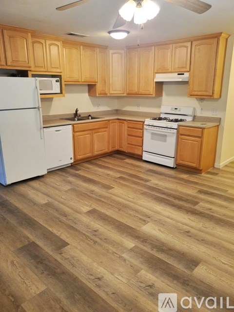 A kitchen with wooden cabinets and a white refrigerator.