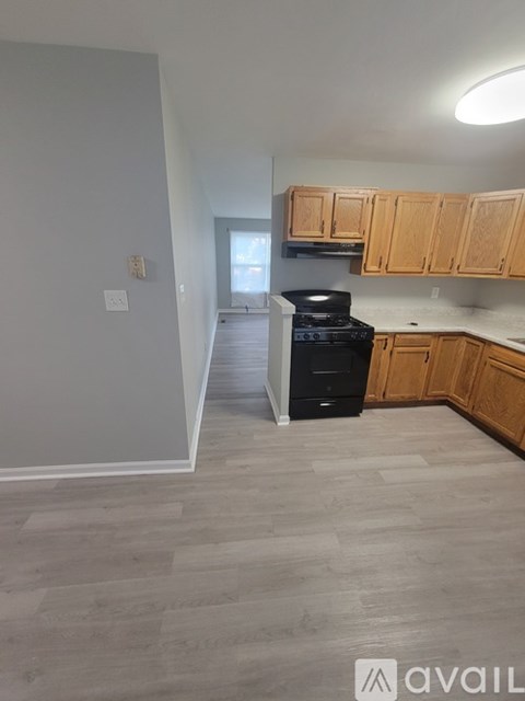 A kitchen with wooden cabinets and a black stove top oven.