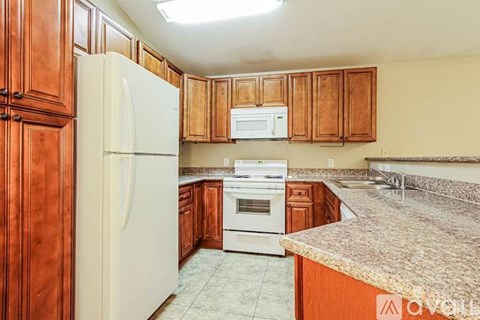 A kitchen with wooden cabinets and a white refrigerator.