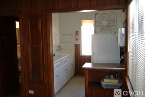 A kitchen with a white fridge and wooden cabinets.