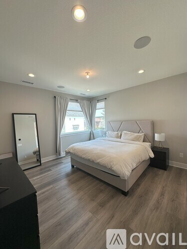 A bedroom with a large bed and a dresser.