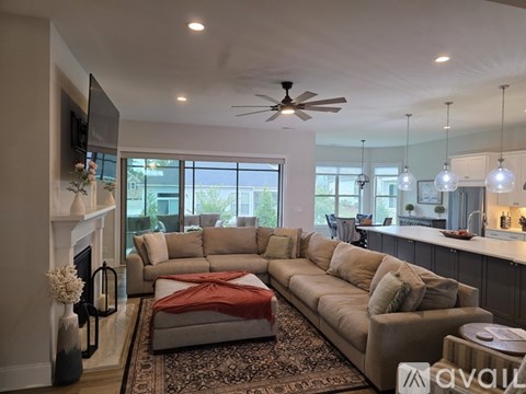 A living room with a beige couch and a rug.