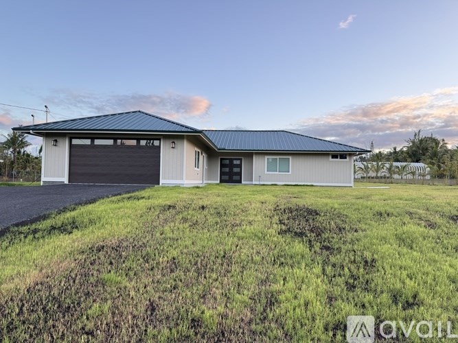 A two-story house with a garage is situated in a grassy area.