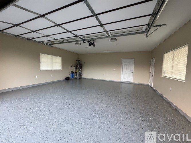 A spacious room with a grey floor and a ceiling with metal beams.
