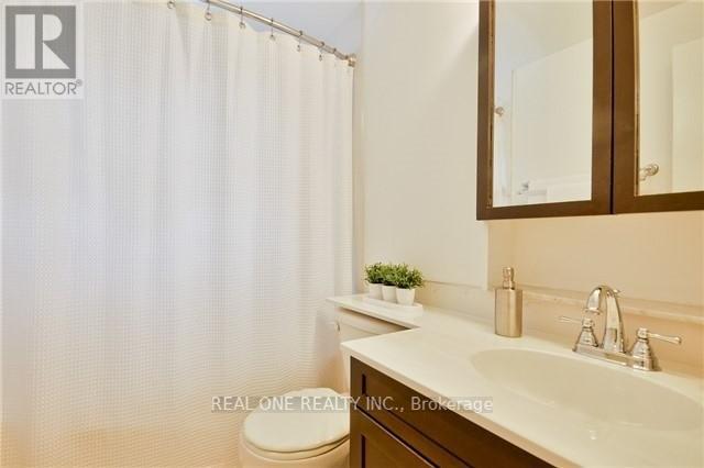 A white sink in a bathroom with a white shower curtain.