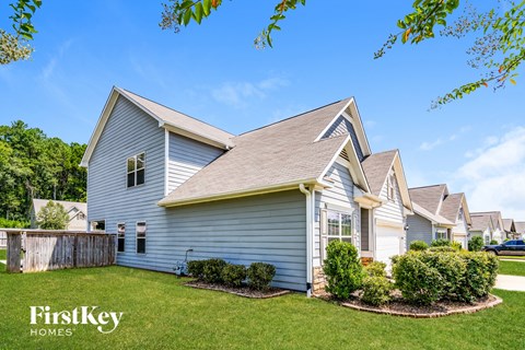 A house with a well-maintained lawn and a clear blue sky above.