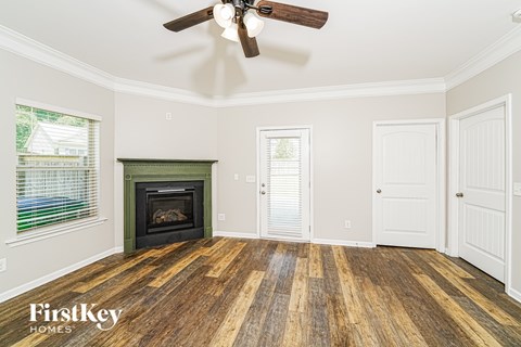 A room with a wood floor and a fireplace.