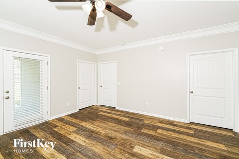 A room with wooden floors and a ceiling fan.