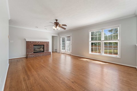 A living room with a fireplace and a ceiling fan.