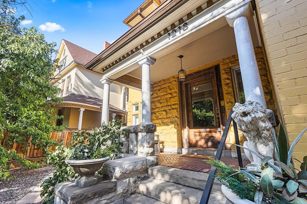 A yellow house with a stone fountain in front.