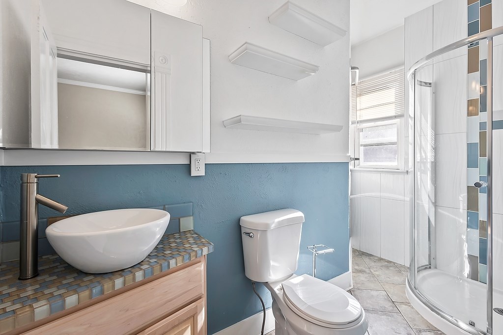 A white toilet sits next to a sink in a bathroom.