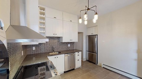 A modern kitchen with white cabinets and a stainless steel refrigerator.