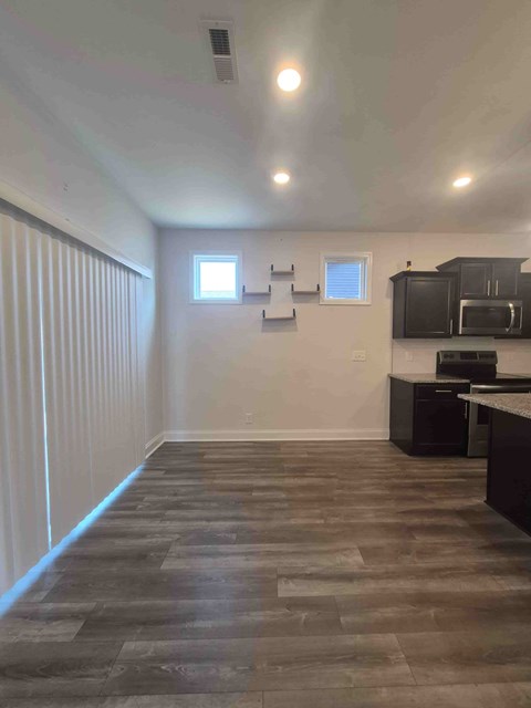 A kitchen with a black counter top and a microwave.