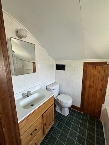 A bathroom with a toilet, sink, and mirror.